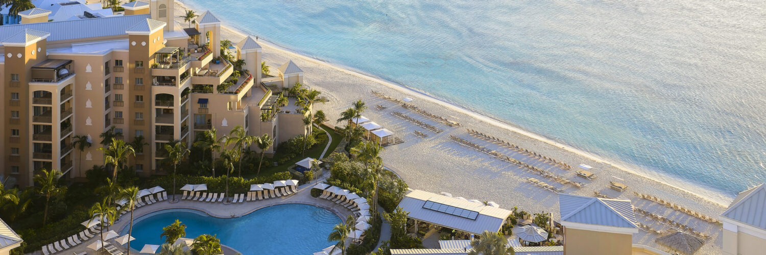 Aerial view of a Grand Cayman beachfront resort and turquoise Caribbean water